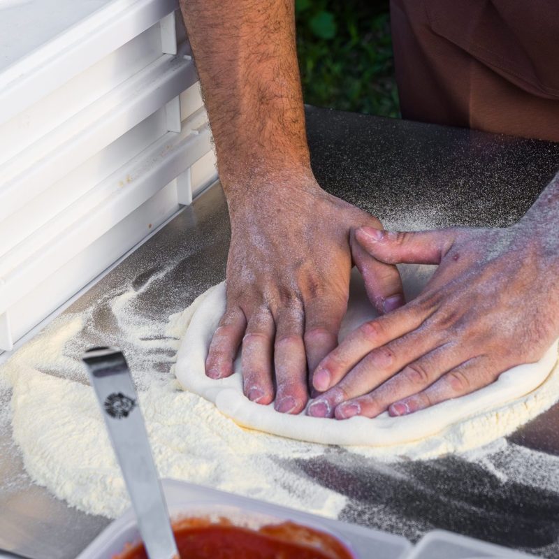 pizzaiolo che stende la pizza napoletana a una festa
